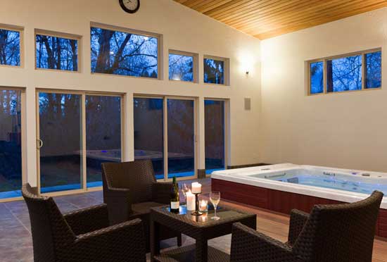 Nicely lit indoor space large windows with a swim spa